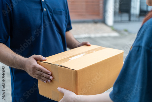 Delivery man holding cardboard boxes. Hand female accepting a delivery boxes of paper containers from courier at home. Signing to get package. Delivery concept.