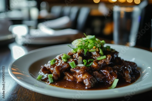 close-up of rich mongolian beef dish in savory sauce with scallions and ambient background