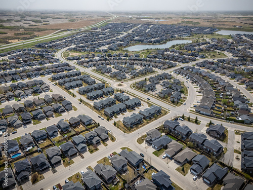 View of a residential neighborhood with many houses and a few cars photo
