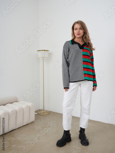 Blonde woman poses in stylish clothing in a modern studio setting