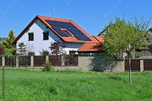 Family house with solar panels on the roof. Home photovoltaic power plant. Concept for industry and green cheaper electricity from renewable sources.