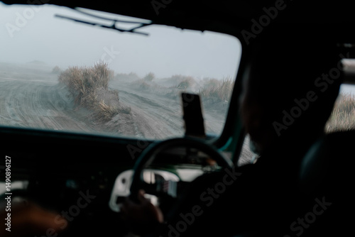 Selective Focus Portrait of an Adventurer at the Wheel Driving a Jeep Through the Volcanic Landscape of Mount Bromo in East Java Indonesia