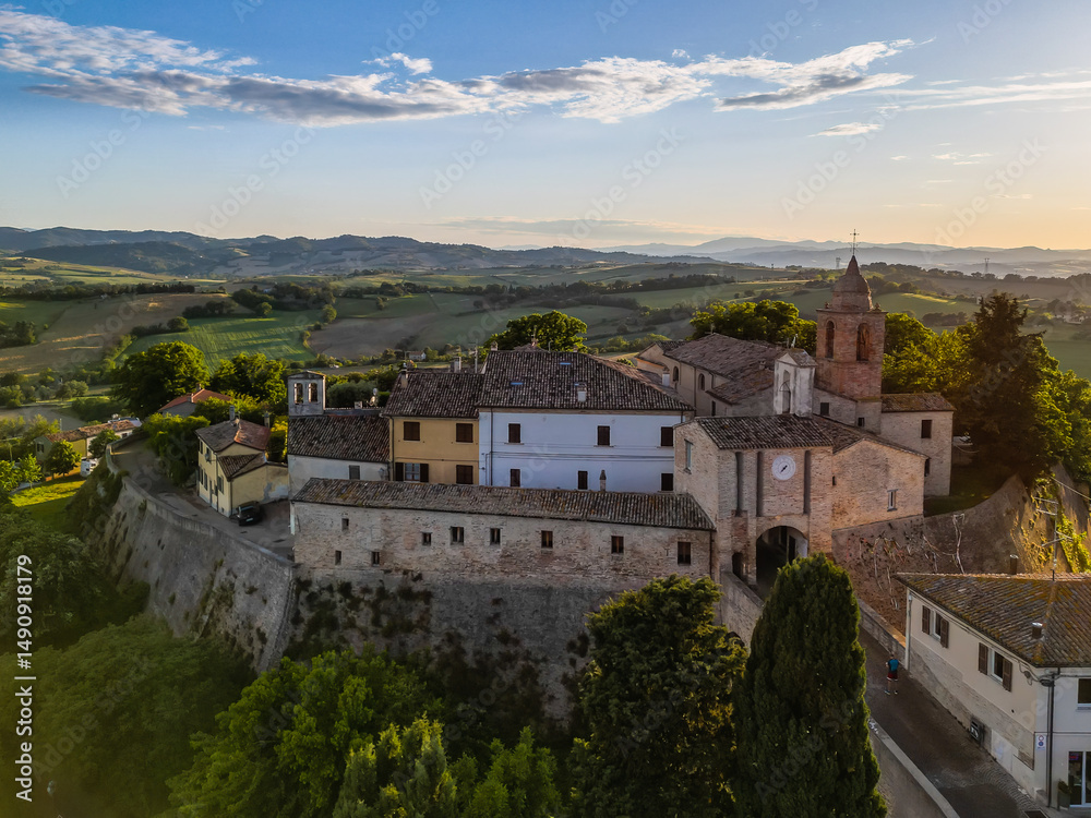 Fototapeta premium Italy, May 15, 2025: aerial view of the medieval village of Candelara in the province of Pesaro in the Marche region. The town exudes ancient history and serenity