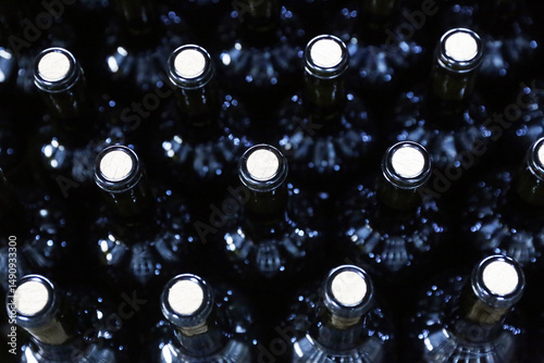 Bottles in a row at wine cellar. Stacked up wine bottles in the cellar