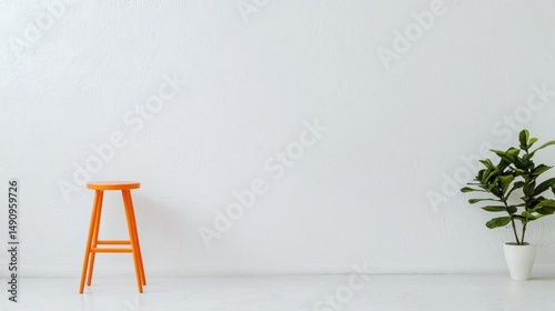White room with a plain white wall and a small orange stool on the left side. on the right side of the image, there is a small potted plant with green leaves in a white pot.