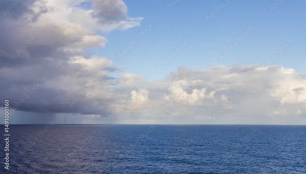 Fototapeta premium Serene Ocean View Underneath Dramatic Cloudscape with Hints of Blue Sky