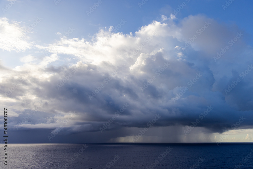 Obraz premium Dramatic Oceanic Cloudscape with Sunlight Piercing Through Over the Tranquil Waters