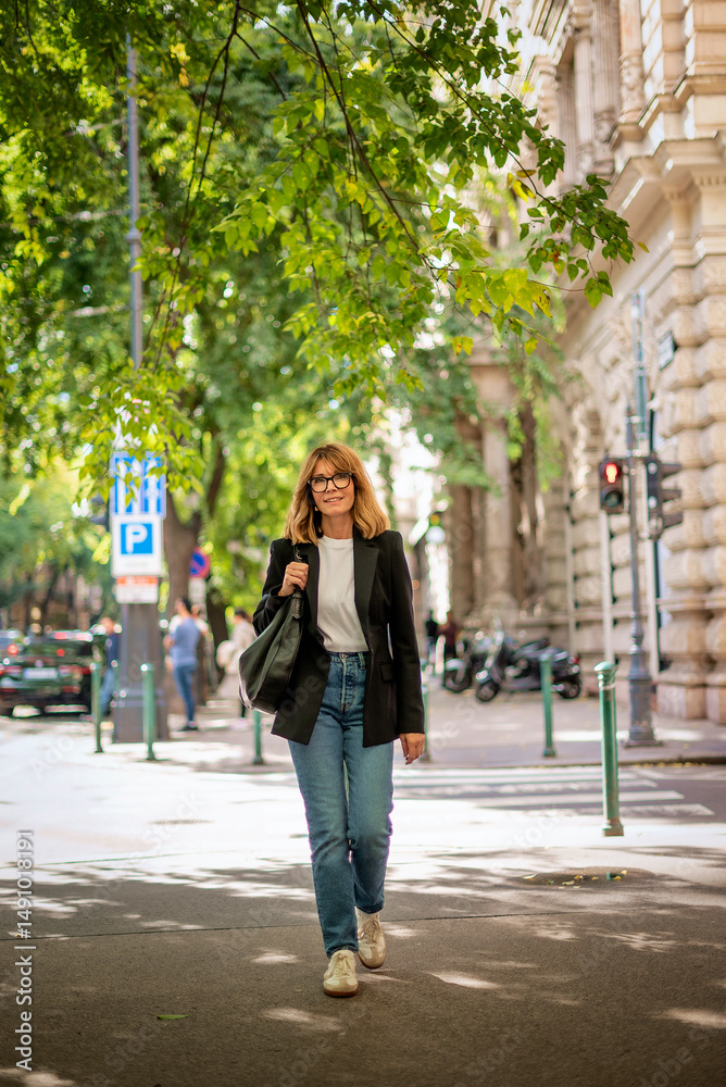 Naklejka premium Blond haired woman walking on the city street on an autumn day