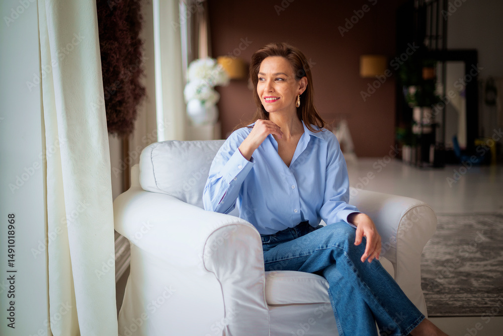 Brunette haired woman relaxing at home in her comfortable armchair Brunette haired woman relaxing at home in her comfortable armchair
