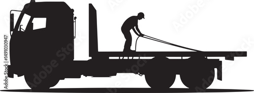 Silhouette of a Flatbed Truck with Worker Securing Load with Ropes on a Bright Day