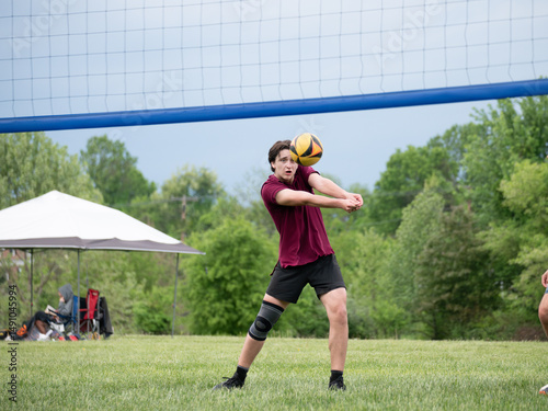 Focused Volleyball player passing the ball during a grass doubles match