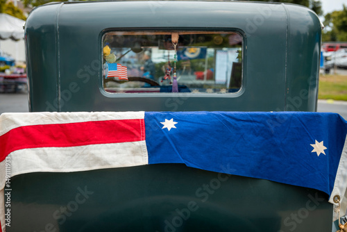 US flag draped over the trunk of a classic car