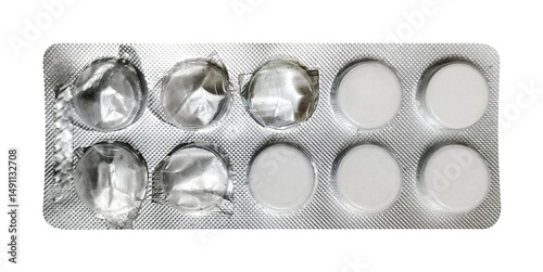Fototapeta A direct overhead shot of a blister pack, prominently displaying four white, round pills on one side and six empty, pressed-out compartments on the other
