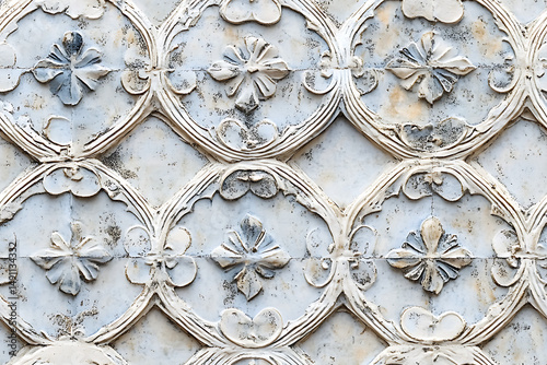 Close up of a white floral pattern with curved shapes and aged texture in a repeating design
