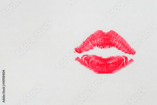 A bright lipstick print on a light surface. Space for text.