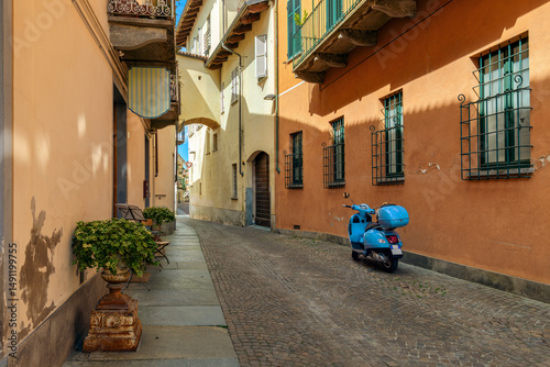 Fototapeta Naklejka Na Ścianę i Meble -  Scooter on the cobblestone street in old town of Alba, Italy.