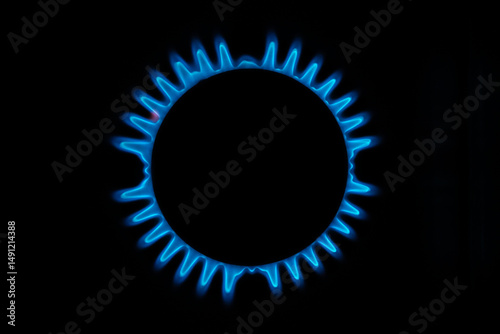 Blue gas flame on a black background. Circular gas burner with blue fire ring.