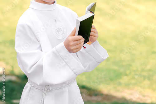 Vászonkép Child praying from prayer book during First Holy Communion – Catholic ceremony a