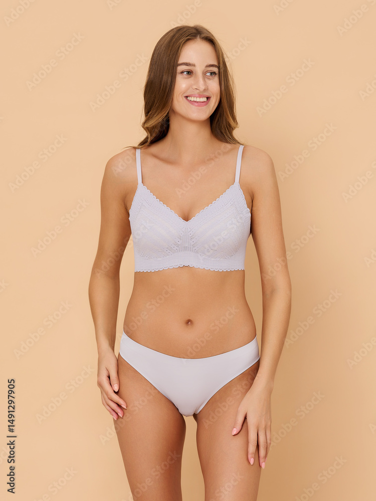 Obraz premium Girl model in underwear posing in studio on beige background.