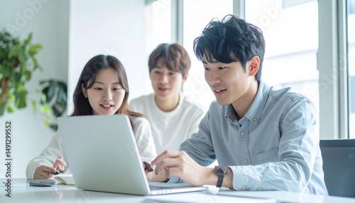 ノートパソコンを囲んで話し合うスタートアップチーム
