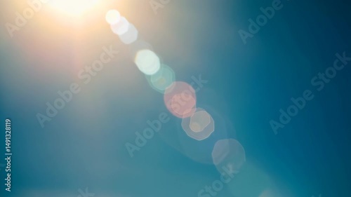 Bright sunlight shining with a long lens flare over gradient blue sky, creating a warm, dreamy, ethereal effect