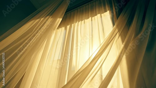 Delicate golden light shining through gently waving sheer curtains in a window casting soft shadows indoors