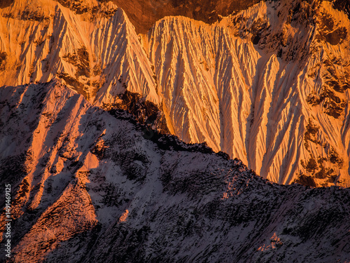 Abstract Detail of Dramatic, Steep Mountain Ridges in the Alps or Tatras, Covered in Snow and Bathed in Intense Golden Sunrise or Sunset Light