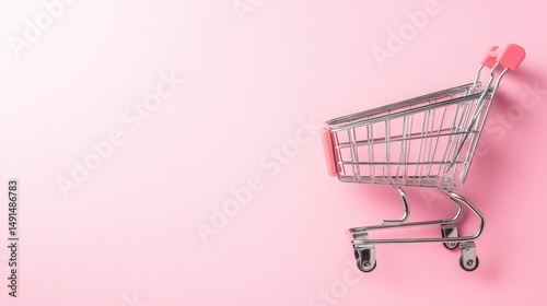 Empty metal shopping cart on a plain pink background, highlighting retail and consumerism themes. The cart is positioned to the right side