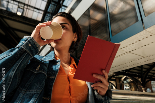 Photography Young woman enjoying coffee while reading book