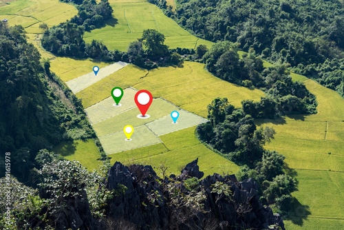 GPS location markers on green rice fields in mountain valley agricultural land planning aerial view..