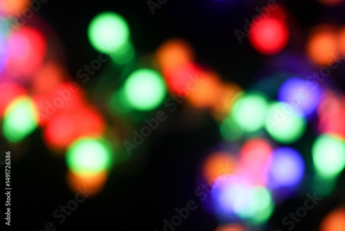 Blurred bokeh background colorful garland on black background
