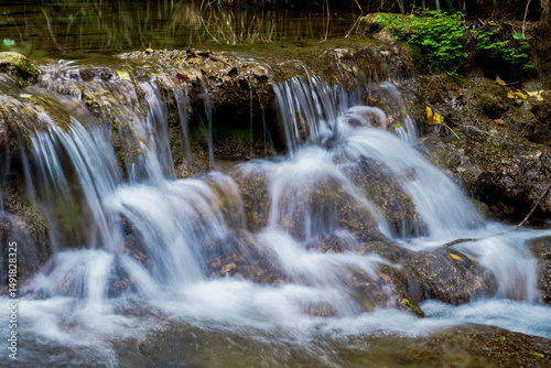 Cascading water flows over rocks in a peaceful natural setting