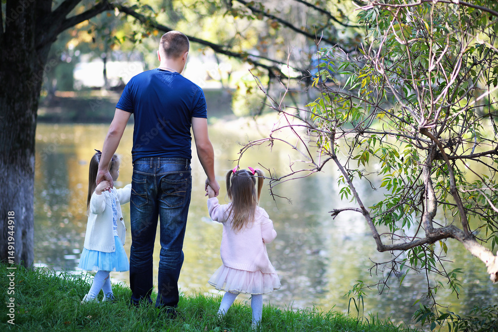 Fototapeta premium Leaf fall in the park. Children for a walk in the autumn park. Family. Fall. Happiness.