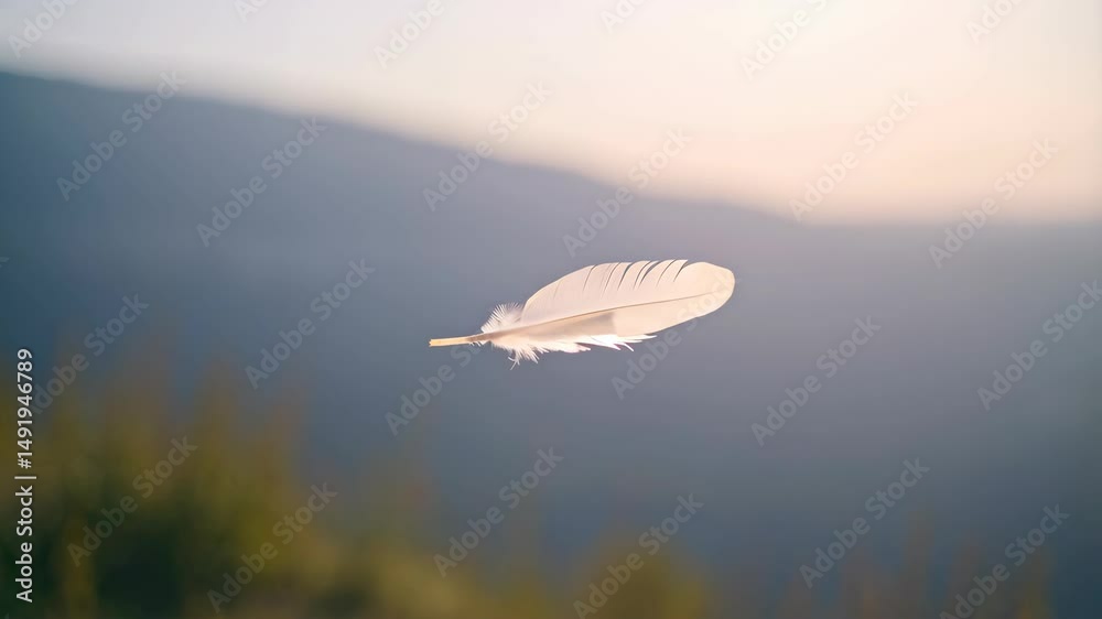 Delicate white feather floating mid-air with blurred mountain range and sky background conveying freedom and lightness feeling dreamlike