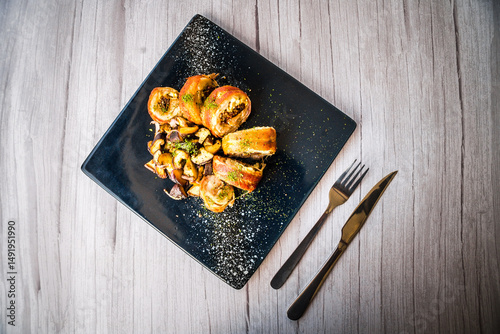 chicken roulade with sauteed mushrooms served on a black platter