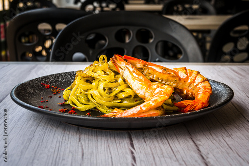 Chimichuri Pasta with Tiger Prawn served on a black plate