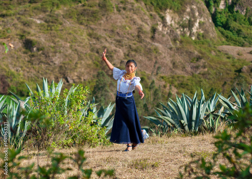 Young indigenous woman dancing in traditional clothes in ecuadorian andes mountains