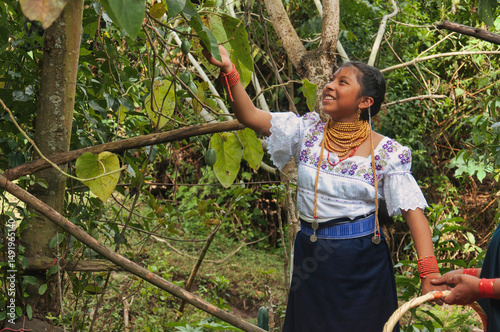 Indigenous girl harvesting tropical fruit in lush rainforest