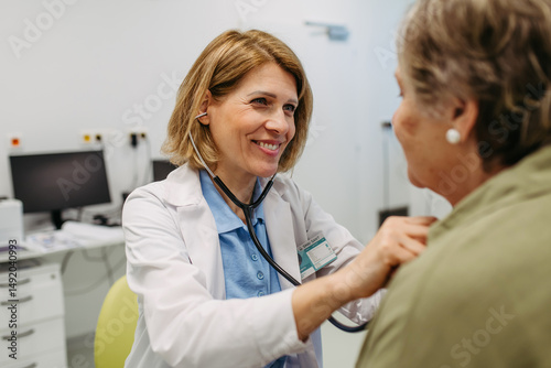 Foto Geriatrician listening to senior patient's heartbeat.