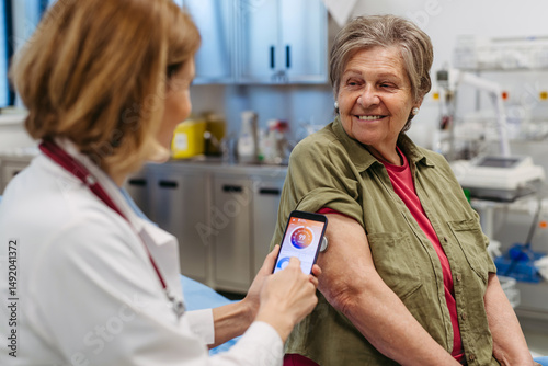 Endocrinologist teaching older patient how to connect continuous glucose monitor with mobil app.