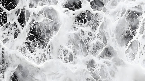 Photograph of marbled texture with swirling, chaotic white veins on a dark background. photo