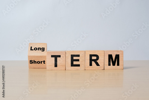 Flipping wooden cube blocks to change 'short term' to 'long term'. Business investment concept.