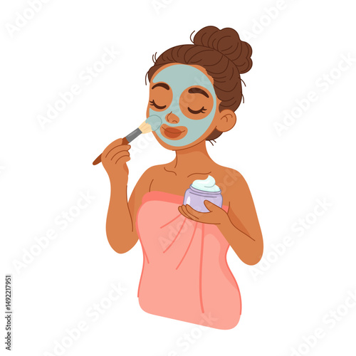 Woman applying facial mask with brush during beauty routine