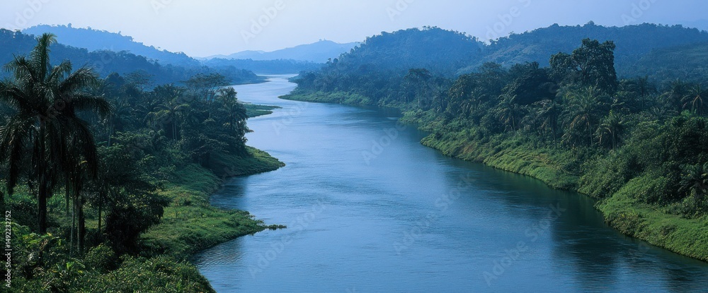 Serene river meanders through lush green landscape. Tranquil waters reflect sky