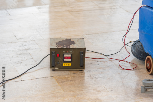 Old transformer to charge battery on, sweeper on stone floor.