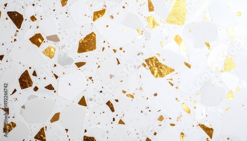 Close-up of terrazzo surface in off-white with embedded gold accents, smooth polished finish with directional lighting