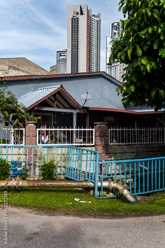 Front porch and blue roof contrasting tall buildings of Kuala Lumpur downtown, Malaysia