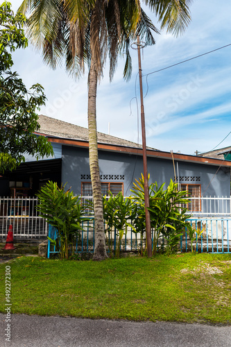Palm tree and house under tropical blue sky, Kuala Lumpur