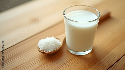 Glass of Milk with Spooned Coconut Flakes on Wooden Table