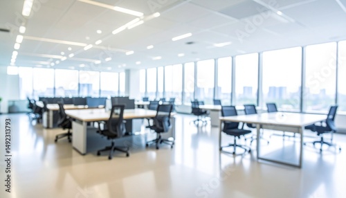 A softly blurred office interior with neutral tones and open-plan desks creates a clean, modern corporate atmosphere. Natural light streams through large windows.